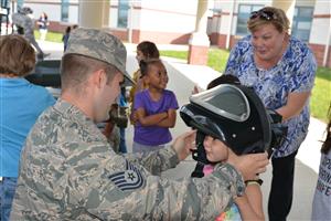 solider putting helmet on preschooler 